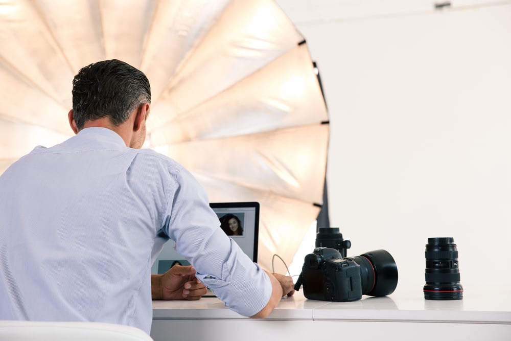 Photographer using laptop in studio