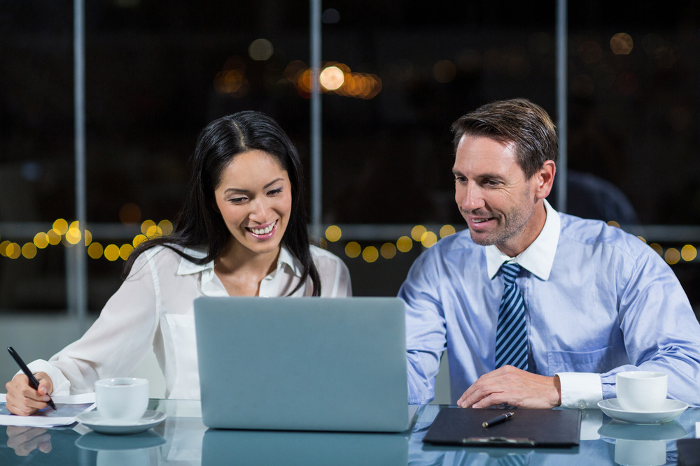 Businessman discussing with colleague over laptop in the office